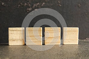 Blank wood scrabble pieces isolated on grunge black background.