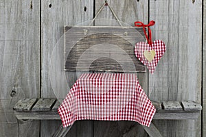 Blank wood sign with red heart over picnic table