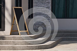 blank wooden chalkboard on curved stone stairway beside of coffee shop