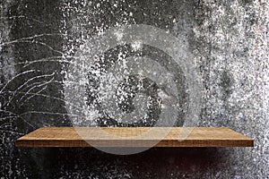 Blank wooden display shelf on cement wall