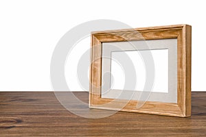 Blank wooden picture frame on table over white background