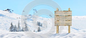 Blank, wooden road sign on snowy mountain, ski resort