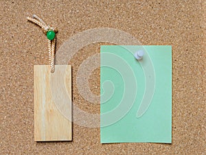 Blank wooden tag and paper on cork board