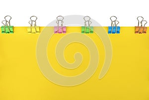 Blank yellow paper with colored paper clips attached around it