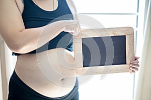 Blank yellow sticker notes on the pregnant woman`s belly. FAQ concept.