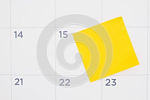 Blank yellow sticky note on a calendar