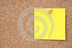 The Blank yellow sticky note paper and wooden thumbtack on wooden background
