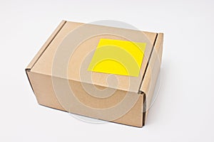 Blank yellow sticky note post on paper box.