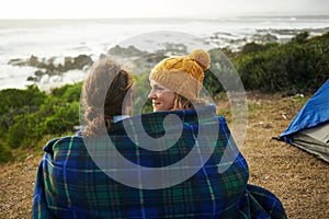 Blanket, love and couple camping in nature for vacation, adventure or holiday together. Happy, conversation and young
