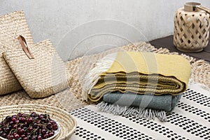 Blankets and rattan bags on table with cherries on the terrace of house. Real photo photo