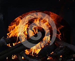 Blazing bonfire surrounded by stacks of logs