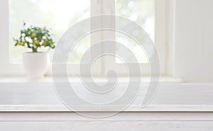 Bleached wooden table on blurred window background with copy space