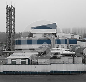 A bleak factory building raising its pipes in the november fog photo