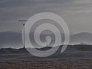 A bleak twilight paysage of a turkish province with power poles and the mountains sillhouettes