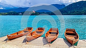 Bled - Group of wooden boats with scenic view of St Mary Church on island of Lake Bled