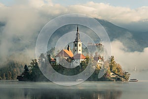 Bled island and castle in morning fog photo