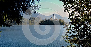 Bled Island with pilgrimage church of the Assumption of Mary and Bled castle on Lake Bled at clear autumn morning