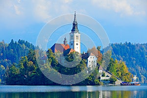 Bled lake island, St Martin Catholic church and Castle. Landscape in Slovenia, nature in Europe. Foggy Triglav Alps with forest, photo