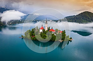 Bled, Slovenia - Beautiful foggy morning at Lake Bled Blejsko Jezero with the Pilgrimage Church of the Assumption of Maria photo