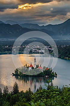 Bled, Slovenia - Golden sky and clouds above Lake Bled Blejsko Jezero with the Pilgrimage Church of the Assumption of Maria photo