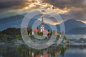 Bled, Slovenia - Misty sunrise at Lake Bled Blejsko Jezero with the Pilgrimage Church of the Assumption of Maria