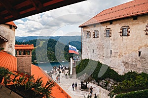 Bled, Slovenia - September, 8 2018: View of the The Bled Castle courtyard full with people, tower and castle buildings with cafes