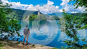 Bled - Tourist man with panoramic view of St Mary Church build on small island on alpine lake Bled