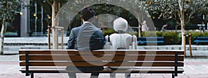 Blend of humanity and artificial intelligence, intimate moment of a man and an AI robot sitting side by side on a bench.