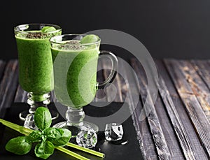 Blended green smoothie with ingredients on wooden table