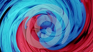 Blended red and blue ink in the background of water on a black background, while creating beautiful swirl shapes.