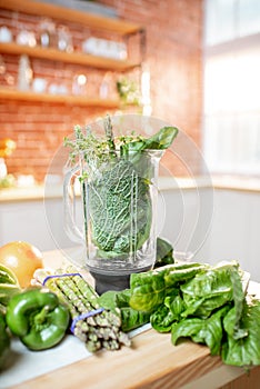 Blender with green raw vegetabes