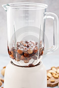 Blender and hazelnuts soaked in water. Making healthy vegan milk