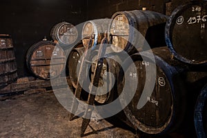 Blending process of cognac spirit and old French oak barrels in cellar in old distillery in Cognac white wine region, Charente,