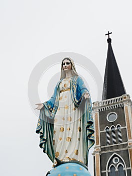 Blessed Virgin Mary, mother of Jesus, statue over cathedral with cross
