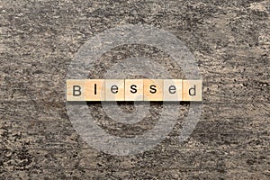 Blessed word written on wood block. Blessed text on table, concept