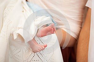 Blessing ritual of child baptism with cute feet inside church