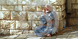 Blind beggar checking coin outside the Basilica of the Annunciation, Nazareth, Israel