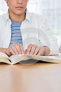 Blind boy reading a braille book