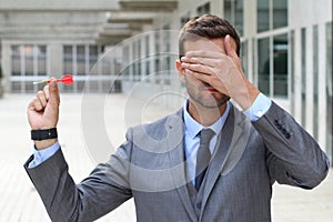 Blind businessman holding a dart