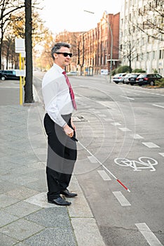 Blind man crossing road photo