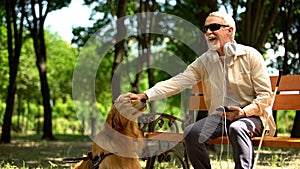 Blind man with earphones stroking dog, full life of impaired, enjoying time