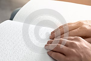 Blind man reading book written in Braille