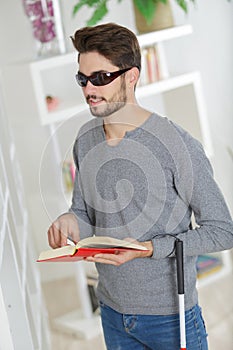 Blind man reading at home
