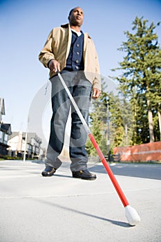 Blind man using a walking stick photo