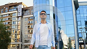 A blind man walking in city and using cane on pavement