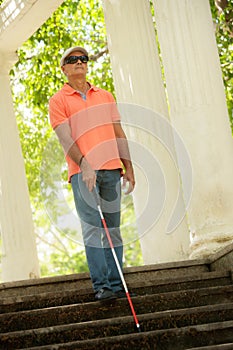 Blind Man Walking And Descending Stairs In City Park