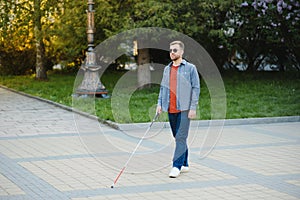 Blind Man Walking On Sidewalk Holding Stick