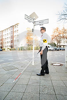 Blind Man Wearing Armband Crossing Road