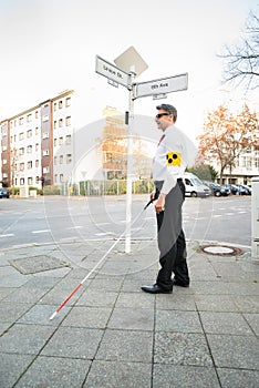 Blind Man Wearing Armband Crossing Road photo
