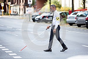 Blind Man Wearing Armband Walking With Stick